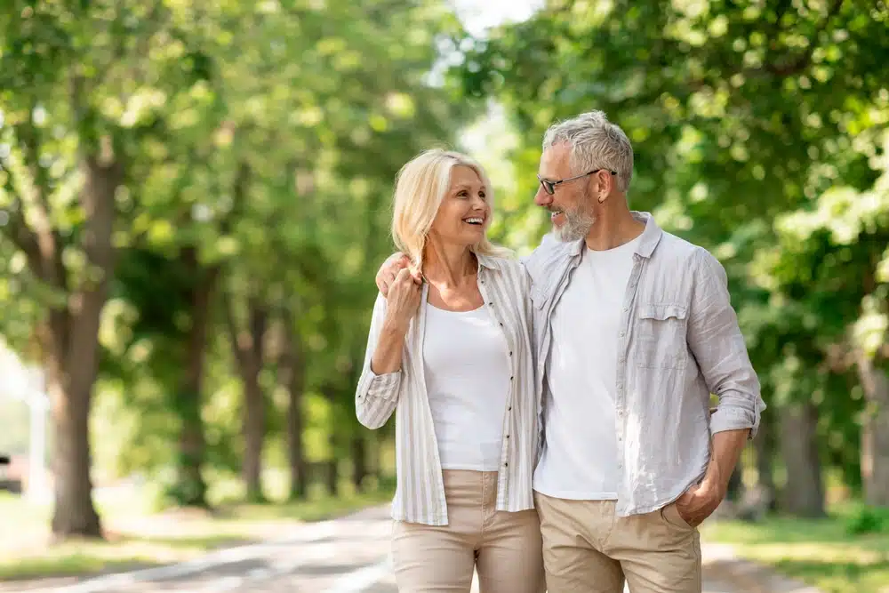 A senior couple discussing Medicare benefits while holding hands, with a focus on how marriage may affect their Medicare coverage.