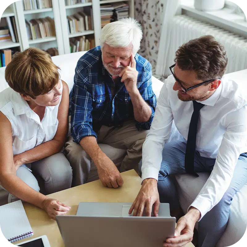 Senior couple reviewing Medicare coverage options with a professional advisor on a laptop.