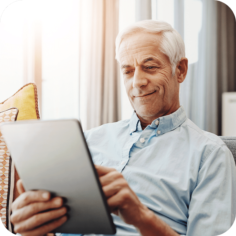 Senior Male looking at Medicare Ebook on Tablet